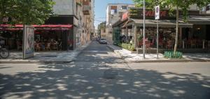 una strada vuota in una città con negozi ed edifici di B&B Artistic Tirana a Tirana