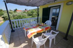 a table and chairs on the balcony of a house at Marašić in Ždrelac
