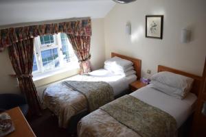 a bedroom with two beds and a window at Clifton Bridge Guesthouse in York