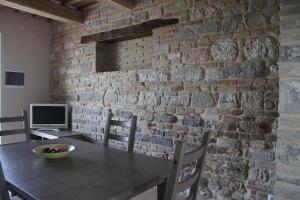 a dining room with a table and a brick wall at Al Castello in San Severino Marche