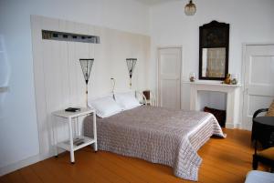 a bedroom with a bed and a table and a clock at B & B Het Lemstra Hûs in Harlingen