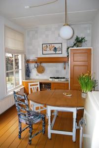 een keuken met een tafel en stoelen in een kamer bij B & B Het Lemstra Hûs in Harlingen