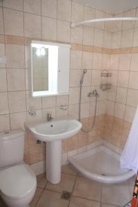 une salle de bain avec un lavabo, des toilettes et une douche dans l'établissement Marthas Studios, à Parga 36 autres photos