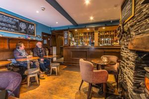 two people sitting at tables in a bar at Penhelig Arms in Aberdyfi