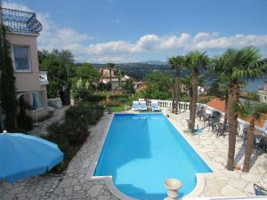 a swimming pool in a resort with palm trees at Apartments Villa Palme in Opatija