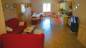 ein Wohnzimmer mit einem roten Sofa und einer Küche in der Unterkunft Antas in Padria