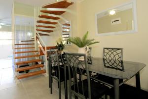 Un comedor con una mesa de cristal y una escalera. en 6 Ipanema Beach, en Durban