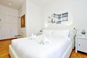 ローマにあるCozy Leone - My Extra Homeの白いベッドルーム(白い大型ベッド1台、白いタオル2枚付)