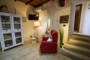 a living room with a red chair and stairs at La finestra sul borgo in Bracciano