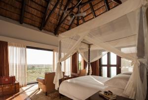 
a large bed with a canopy over it at Four Seasons Safari Lodge Serengeti in Banagi

