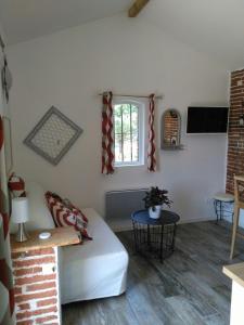ein Wohnzimmer mit einem weißen Sofa und einem Fenster in der Unterkunft Les Hauts de Sames in Deyme