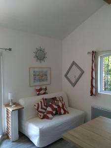 ein Wohnzimmer mit einem weißen Sofa und einem Fenster in der Unterkunft Les Hauts de Sames in Deyme