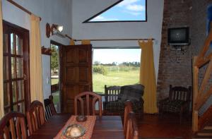 Un comedor con mesa y sillas y una ventana. en Cabañas Tierra Linda, en Concepción del Uruguay