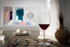 a glass of red wine sitting on a table at Kima Oia Suites in Oia