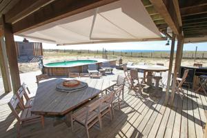 a patio with a table and chairs and a pool at Villa Lodge Natureo in Seignosse