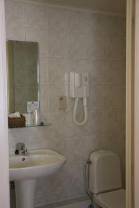 a bathroom with a sink and a toilet and a mirror at Il Siciliano - Duc de Bouillon in Bouillon