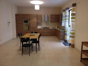 a kitchen with a table and chairs in a room at Mandalay in Mellieħa