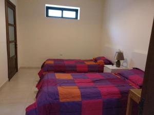 a bedroom with two beds and a window at Mandalay in Mellieħa