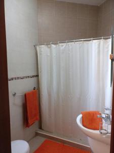 a bathroom with a white shower curtain and a sink at Mandalay in Mellieħa