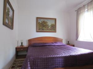 sypialnia z fioletowym łóżkiem i oknem w obiekcie Apartments Villa Palme w mieście Opatija +37 zdjęć