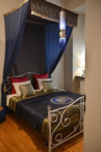 クラクフにあるLa Gioia Magic Orient Apartmentsのベッドルーム1室(青い天蓋付きのベッド1台付)