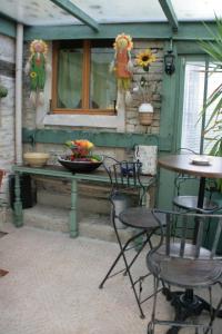 a patio with two chairs and a table and a table at Chambres d'Hôtes de La Vallée Du Serein in Annay-sur-Serein