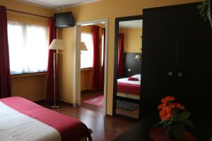 a hotel room with a bed and a mirror at Il Siciliano - Duc de Bouillon in Bouillon