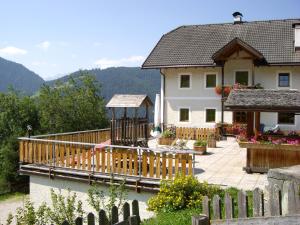 een huis met een houten terras naast een huis bij Soroea in San Vigilio Di Marebbe