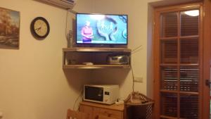 a living room with a television and a clock at Apartma TR 43 in Moravske-Toplice