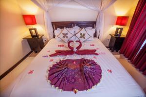 a bedroom with a bed with an umbrella on it at Mans Cottages & Spa in Pemuteran