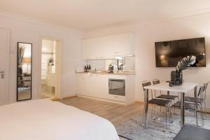 een slaapkamer met een bed en een tafel en een keuken bij Top city center location by Airhome in Zug