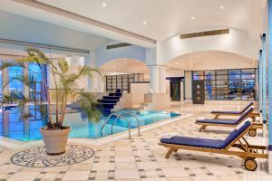 a house with a pool and a palm tree in it at Corinthia Tripoli in Tripoli