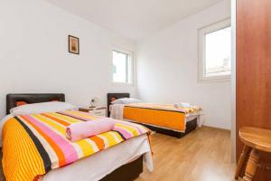 um quarto com duas camas e uma mesa e duas janelas em Apartmani Dotur em Split