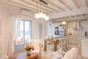 eine Küche und ein Wohnzimmer mit einem Tisch und Stühlen in der Unterkunft Passos Villas in Parasporos