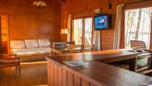 a living room with a couch and a television in a cabin at Hotel Horacio Quiroga in Termas de Salto Grande
