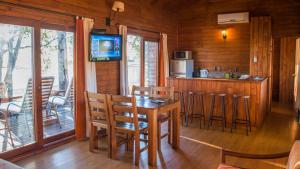 a dining room with a table and chairs in a cabin at Hotel Horacio Quiroga in Termas de Salto Grande