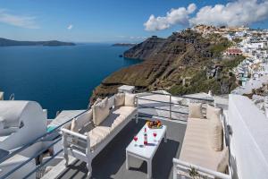 a balcony on a yacht with a view of the ocean at 1809 Villa in Fira