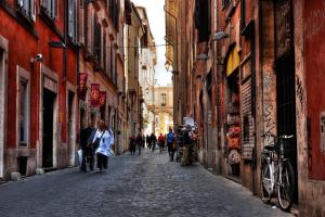 a group of people walking down a cobblestone street at G-House Pettinari in Rome