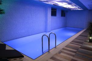 einen Pool in einem Zimmer mit blauer Beleuchtung in der Unterkunft Rios Edition Hotel in Istanbul