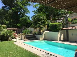a swimming pool in a yard with a garden at B&B Garonnella in Toulouse