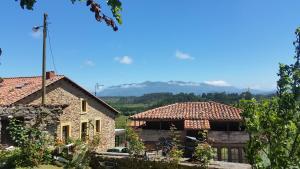a farmhouse with a view of the mountains in the background at Turismo rural El Piensu in Villaviciosa
