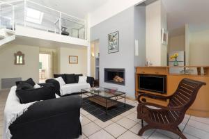 a living room with a couch and a fireplace at Madame Vacances Villas La Prade in Moliets-et-Maa