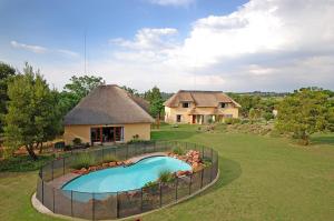 a home with a swimming pool in front of a house at Hoopoe Haven Guest House in Chartwell