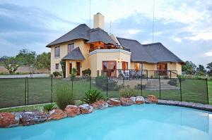 a large house with a swimming pool in front of it at Hoopoe Haven Guest House in Chartwell