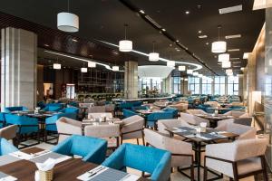 ダナンにあるMuong Thanh Luxury Danang Beach Hotelのダイニングルーム(青いテーブル、椅子付)