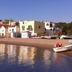 un homme est dans un bateau sur la plage dans l'établissement Appartamento Ischia Isola, à Ischia