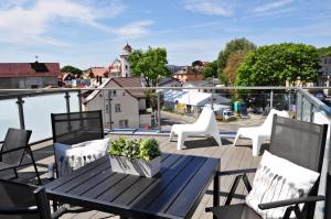 ミエンジズドロイェにあるMiędzyzdrojski Rynek by Baltic Homeのバルコニーにテーブルと椅子が置かれたパティオ