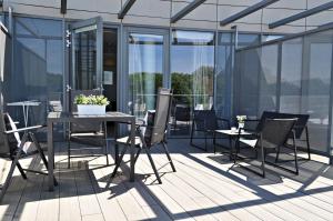 ミエンジズドロイェにあるMiędzyzdrojski Rynek by Baltic Homeのバルコニーにテーブルと椅子が置かれたパティオ