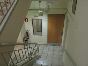 a hallway with a staircase with a mirror and a door at Delphi Hotel in Nicosia