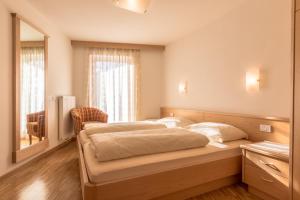 ラ・ヴィッラにあるCiasa Dolomitesのベッドルーム(ベッド1台、大きな鏡付)